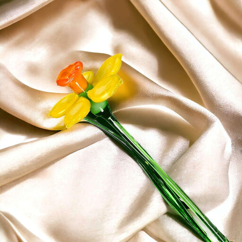 a yellow and orange flower sitting on top of a white cloth