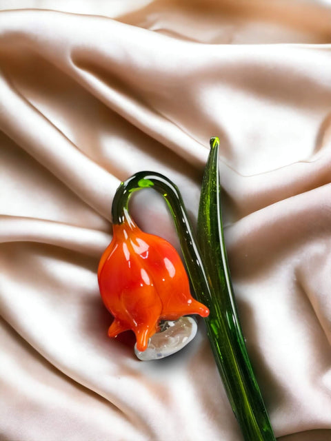 an orange flower sitting on top of a white cloth