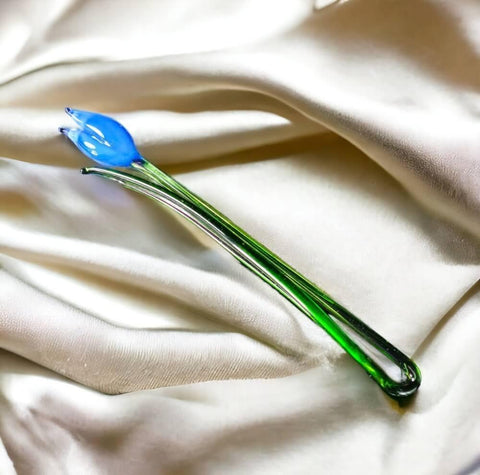 a blue and green toothbrush laying on a white cloth