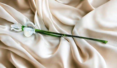 a white flower laying on top of a white sheet