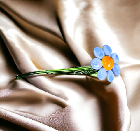 a flower on a satin surface with water droplets