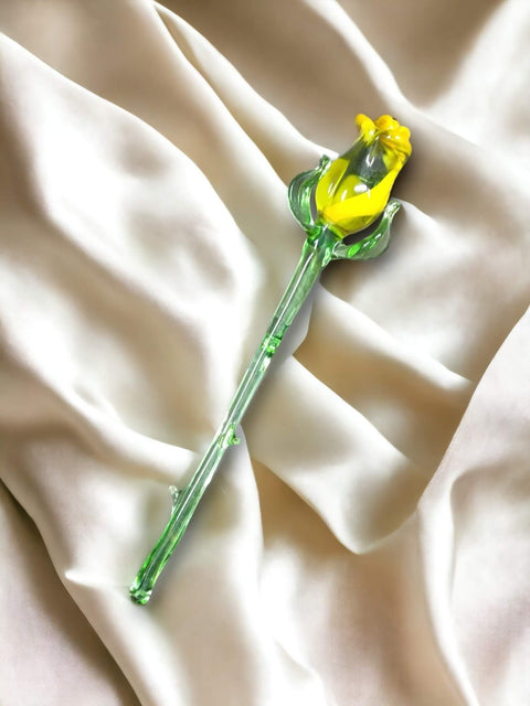 a single yellow flower sitting on top of a white sheet