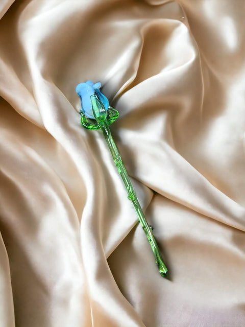 a single blue rose on a satin fabric