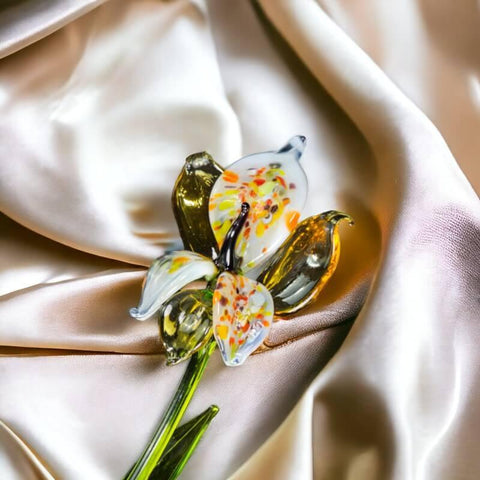 two glass birds sitting on top of a satin