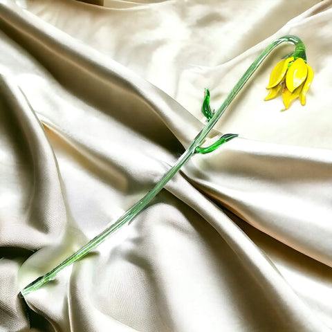 a yellow flower on a white satin sheet